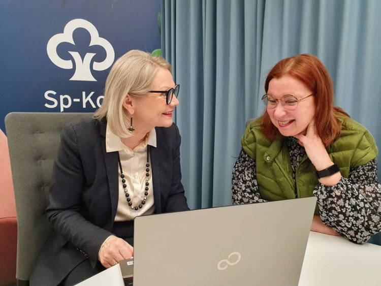 Kaksi naista juttelevat tietokoneen äärellä